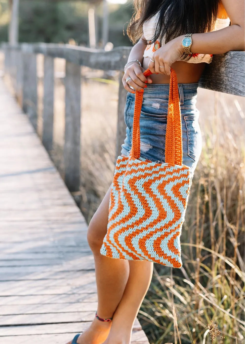 Jonge vrouw houdt Zigzag Bag vast in mooie omgeving