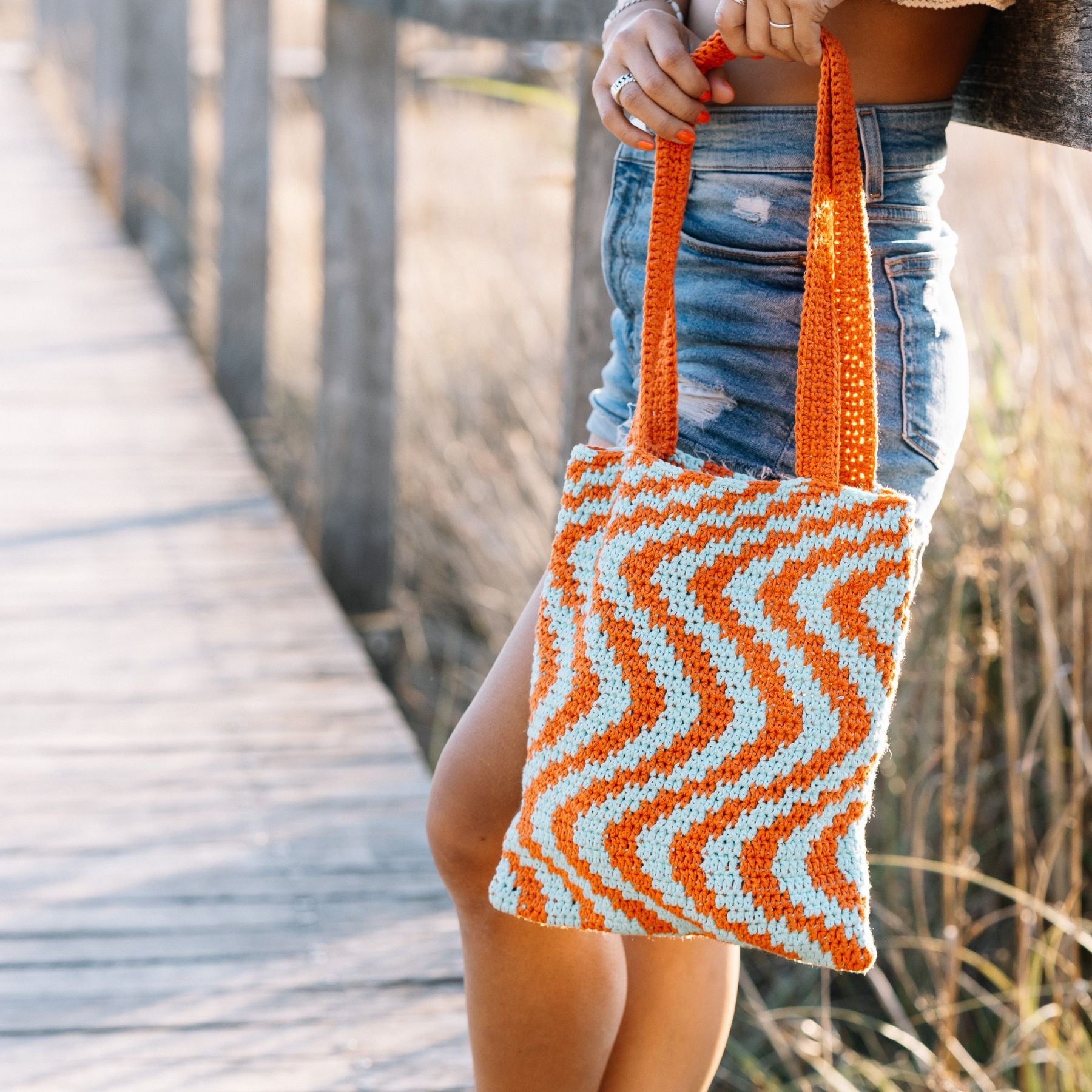 Jonge vrouw houdt Zigzag Bag vast in mooie omgeving