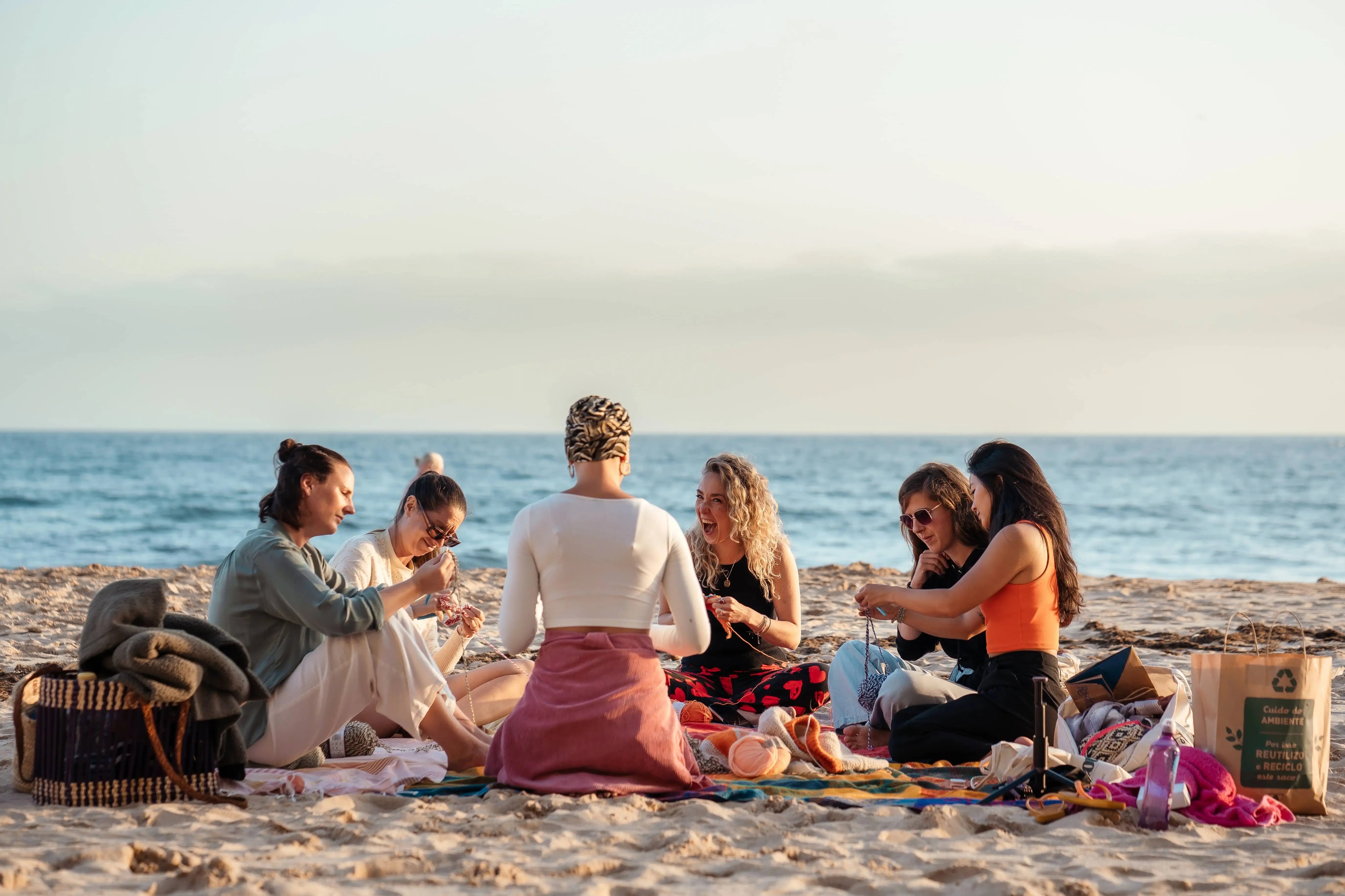 Vrouwen haken op het strand met zonsondergang